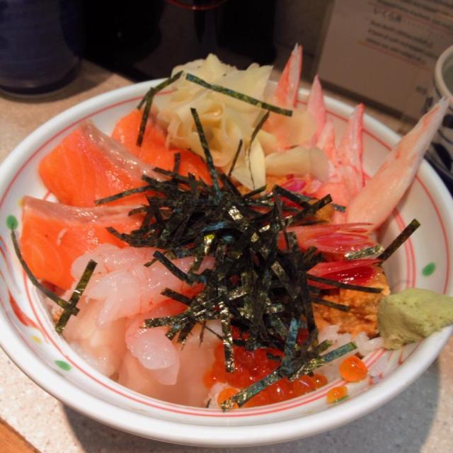 Hokkaizanmai-don: raw snow crab, deep-water shrimp, sea urchin, salmon, salmon roe and scallops on top of a bowl of hot steaming sushi rice.
