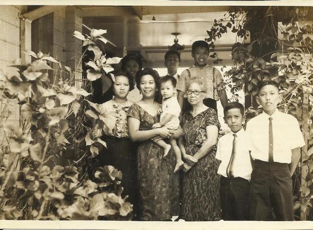 Lola carrying Papa in our family compound in Cubao with my uncles and aunts in their younger years.