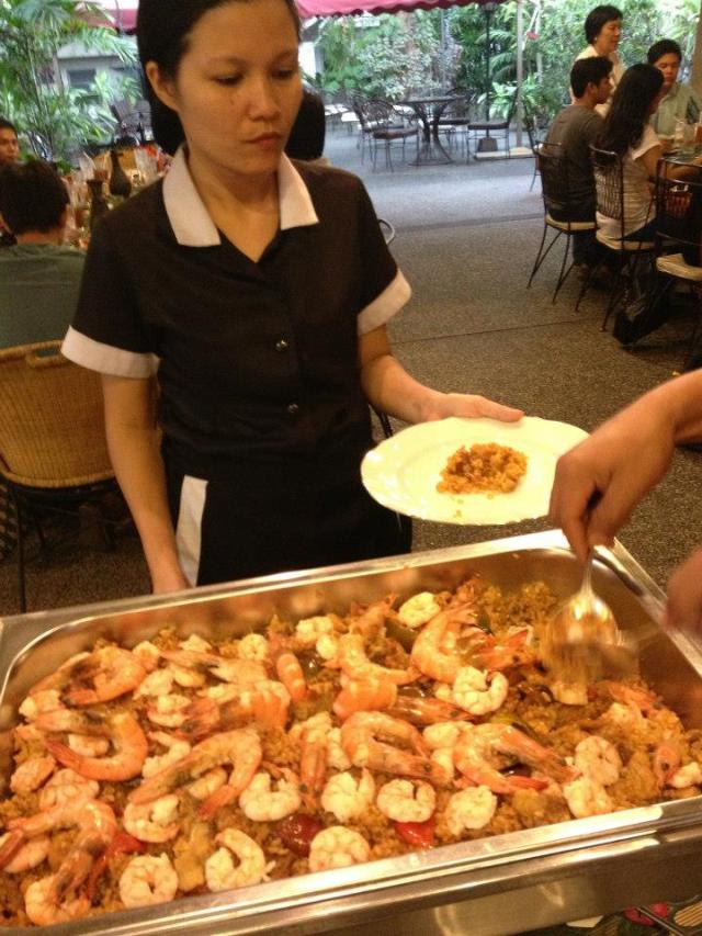 Members of the staff putting paella valenciana on the plates of students I brought to La Cocina on one occasion 